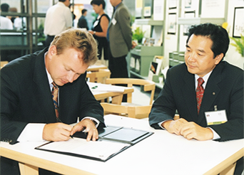世界図書会場にて宮﨑社長とBCI社アズボーン・トムセン社長が共同契約書に調印