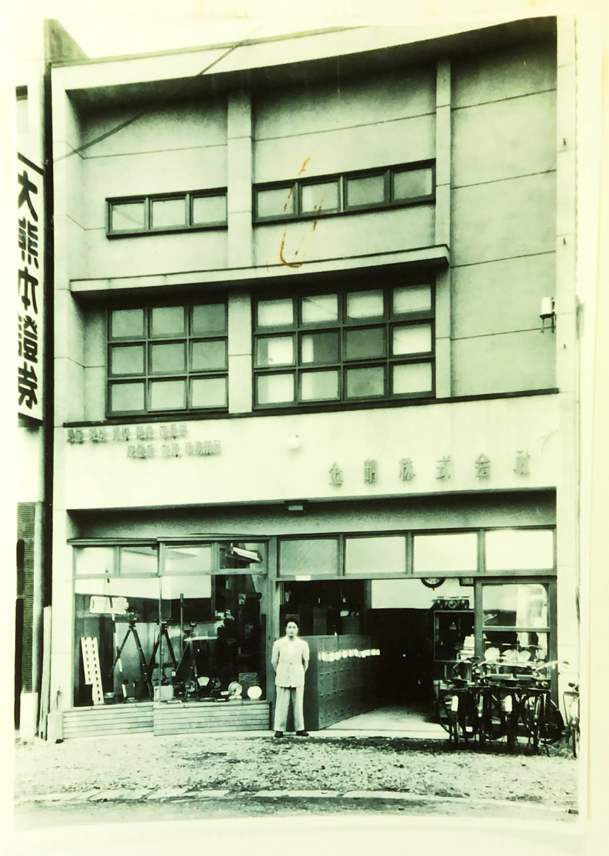 初期の銀座通りの店舗前に立つ谷脇社長
